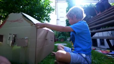 Child painting with brush outside. Creative kid