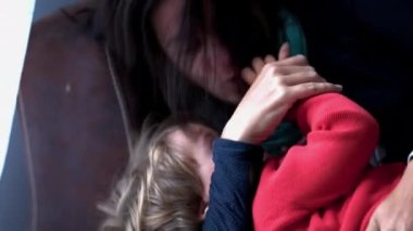 Mother filling child with kisses. casual authentic real life family love and affection