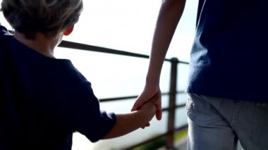 Çocuklar el ele tutuşup dışarıda yürüyorlar.