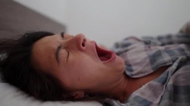 Yatakta uzanan kadın sabah uyanır.