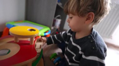 Toddler kid playing with toys in room