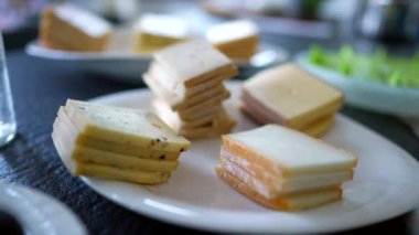 Slices of cheese on plate, traditional swiss raclette pieces