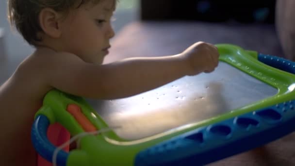 Kleiner Junge Spielt Mit Magnetischem Reißbrett — Stockvideo