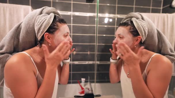 Lustige Frau Mit Gesichtsmaske Vor Badezimmerspiegel Abgedeckt Macht Spaß — Stockvideo