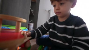 Child plays with toy car in room