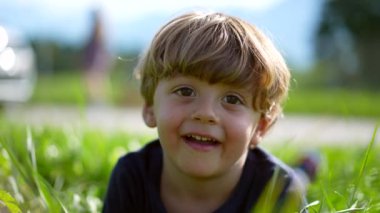 Little boy on grass portrait outside, cute little child