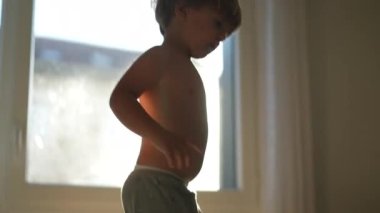 Evdeki kanepede zıplayan neşeli çocuk.