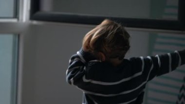 Little boy shutting window home. Child closes window