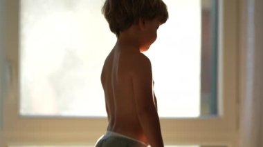 Child jumping on couch, little boy standing on table jumps on sofa