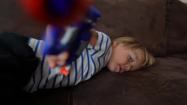 Ребенок Тычет Игрушечным Пистолетом Камеру Один Маленький Мальчик — стоковое видео
