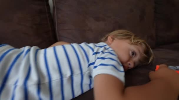 Βαρετό Παιδί Ξαπλωμένο Στον Καναπέ Του Καναπέ Στο Σπίτι Κρύβεται — Αρχείο Βίντεο