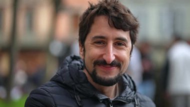 Sıradan genç adam portresi gülümseyen, kendiliğinden gülümseyen ve gülen.