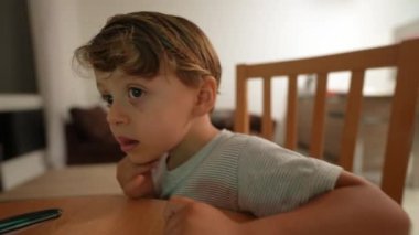 Küçük çocuk evde film izleyen ekran çocuğu tarafından hipnotize edildi.