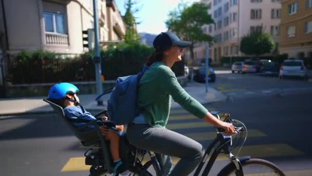 Woman Riding Bicycle Urban Street Child Back Seat — Stock Video