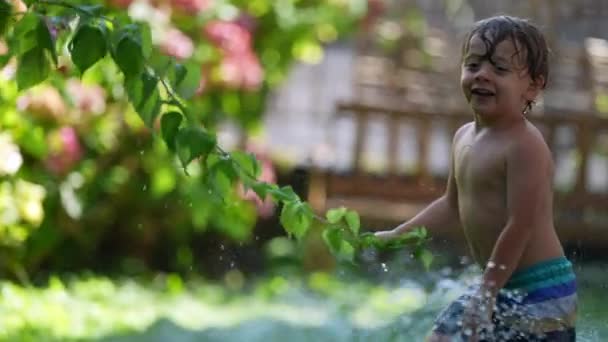 Παιδί Παίζει Έξω Σπρέι Νερού Γελώντας Και Χαμογελώντας — Αρχείο Βίντεο