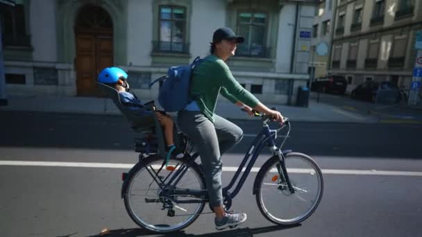 Gelukkig Vrouw Rijden Fiets Met Slapend Kind Achterbank Stedelijke Straat — Stockvideo