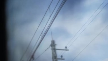 Bulanık POV yolcusu trenle gidiyor geçen kablolara bakıyor.