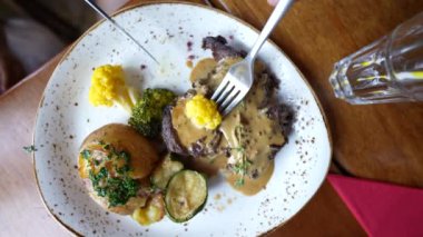 Restoranda yemek yiyen kişi lezzetli yemekler yer.