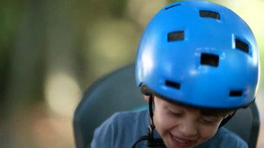 Bisiklet kaskı takan, gülen ve gülümseyen küçük çocuk.