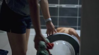 Çamaşır makinesinin içine çamaşır koyan kişi gerçek bir ev hayatı yaşıyor.