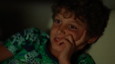 Geceleri televizyon izleyen küçük bir çocuk.