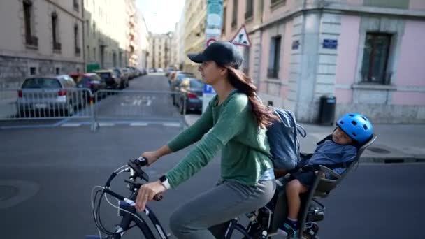 Проезжающая Велосипеде Улице Спящим Ребенком Заднем Сиденье Мать Ездит Велосипеде — стоковое видео