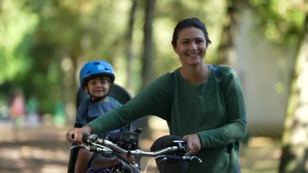 Mor Som Bär Cykel Utomhus Parken Med Barn Baksätet Cykel — Stockvideo