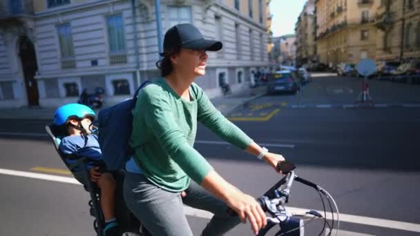 Kobieta Jazda Rowerze Miejskiej Ulicy Dzieckiem Tylnym Siedzeniu — Wideo stockowe