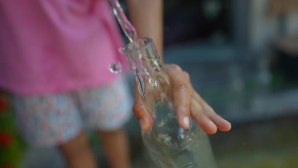儿童手拿着水龙头的瓶装水 — 图库视频影像