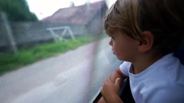 Παιδί Κοιτάζει Έξω Από Παράθυρο Του Λεωφορείου Που Ταξιδεύουν Μέσα — Αρχείο Βίντεο