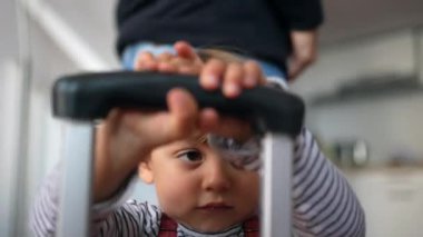 Küçük çocuk bagaj sapı nesnesiyle oynuyor