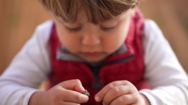 Küçük çocuk taşlarla oynuyor. Çocuk çamur kayasıyla oynuyor