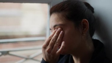 Elle gözünü ovuşturan bir kadın. Yorgun insan gözlerini ve yüzünü ovar.