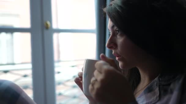 隣の窓からコーヒーを飲んでいる女 — ストック動画