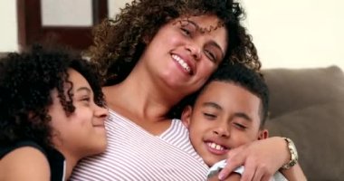 Mutlu Afrikalı anne ve çocuk ilişkileri. Anne kızı ve oğlunu öpüyor ve kucaklıyor.