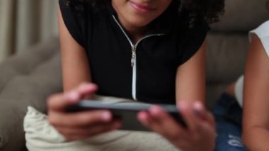 Brezilyalı çocuk akıllı telefon cihazıyla medyanın keyfini çıkarıyor. Güney Amerikalı genç kız cep telefonunu izliyor.