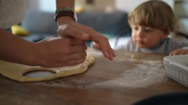 Anne, bebek bebekle evde yemek pişiriyor.