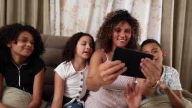 Aile uzun mesafeli video konferansında el sallıyor.