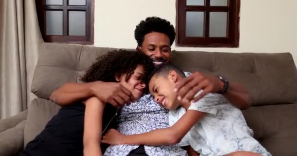 Afrikansk Far Omfamnar Dotter Och Son Tillsammans Soffa Vardagsrum — Stockvideo