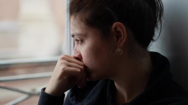 一个多愁善感的女人透过窗户往外看 一个思考问题的人在想生活 — 图库视频影像