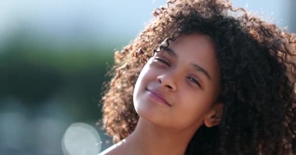 外のカメラの前で笑っている黒人の未成年の少女 巻き毛のアフリカ人の子供 — ストック動画