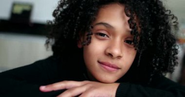 Genç kız kameraya bakıp gülümsüyor. Sevimli küçük çocuk gülüşü