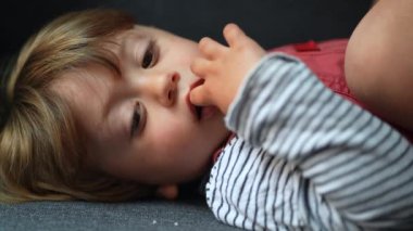 Kanepede el ele uzanmış dalgın bir çocuk. Düşünceli çocuk.