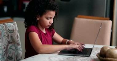 Evde dizüstü bilgisayar kullanan küçük bir kız çocuğu. Gizli çocuk internette geziniyor.