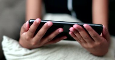 Cep telefonu tutan çocuk video içeriğini çevrimiçi izliyor