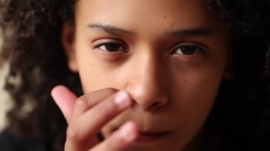 Çocuk elleriyle yüzünü tırmalıyor. Kız parmaklarıyla yüzüne dokunuyor.