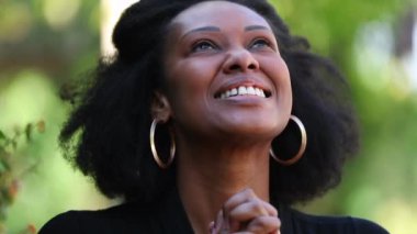 Umut dolu Afrikalı kadın umutla ve inançla gökyüzüne bakıyor.