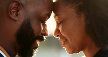 Afrikalı çift alınları birbirine bakıyor ve alevlerle öpüşüyor.