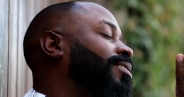 Mutlu iyimser Afrikalı adam gökyüzüne umutla ve inançla bakıyor.