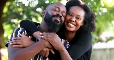 Sarılıp kucaklaşan Afrikalı çift kameraya bakıyor, iki romantik çift.